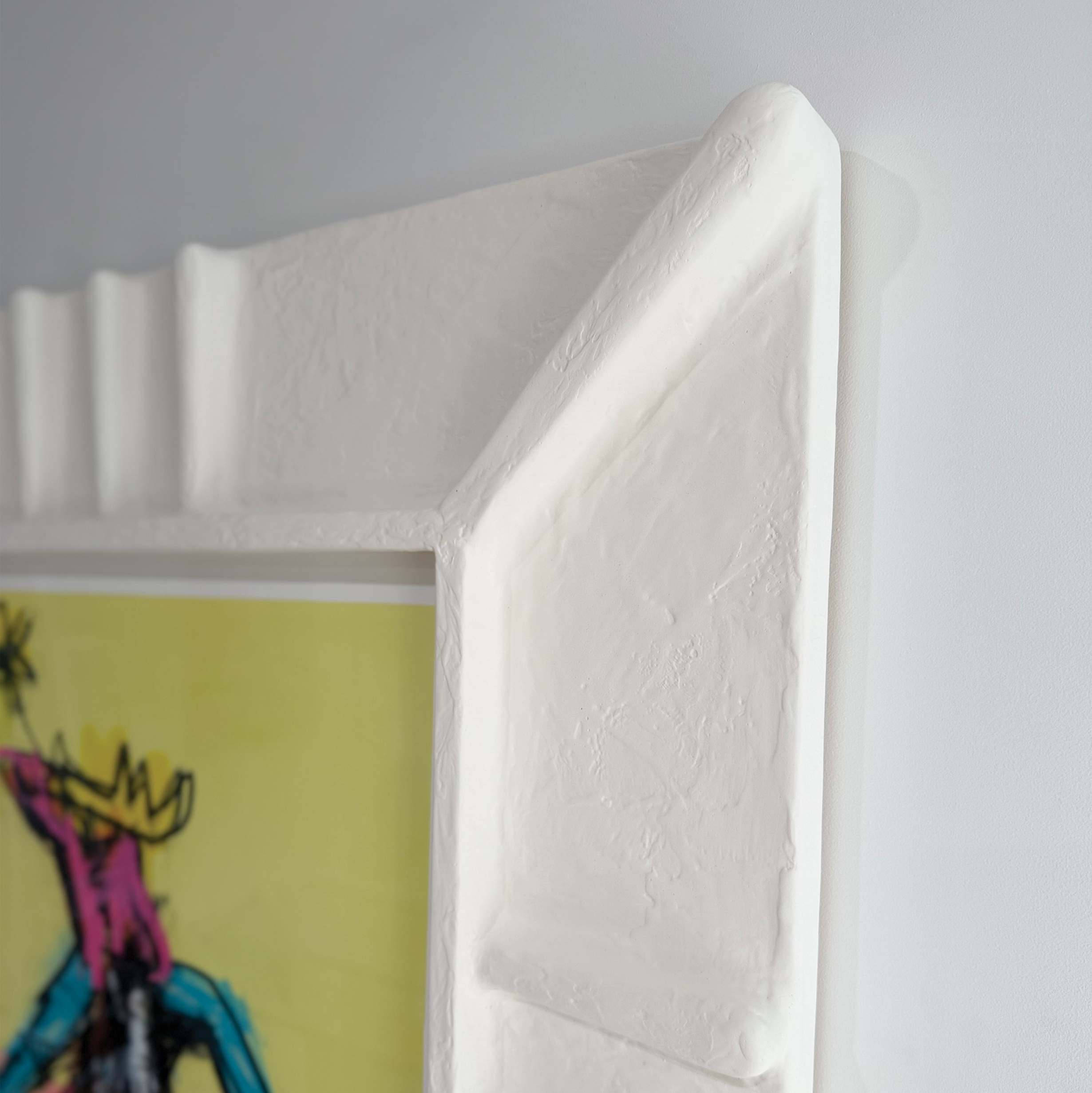 corner detail of Pueblo handcrafted frame against white wall