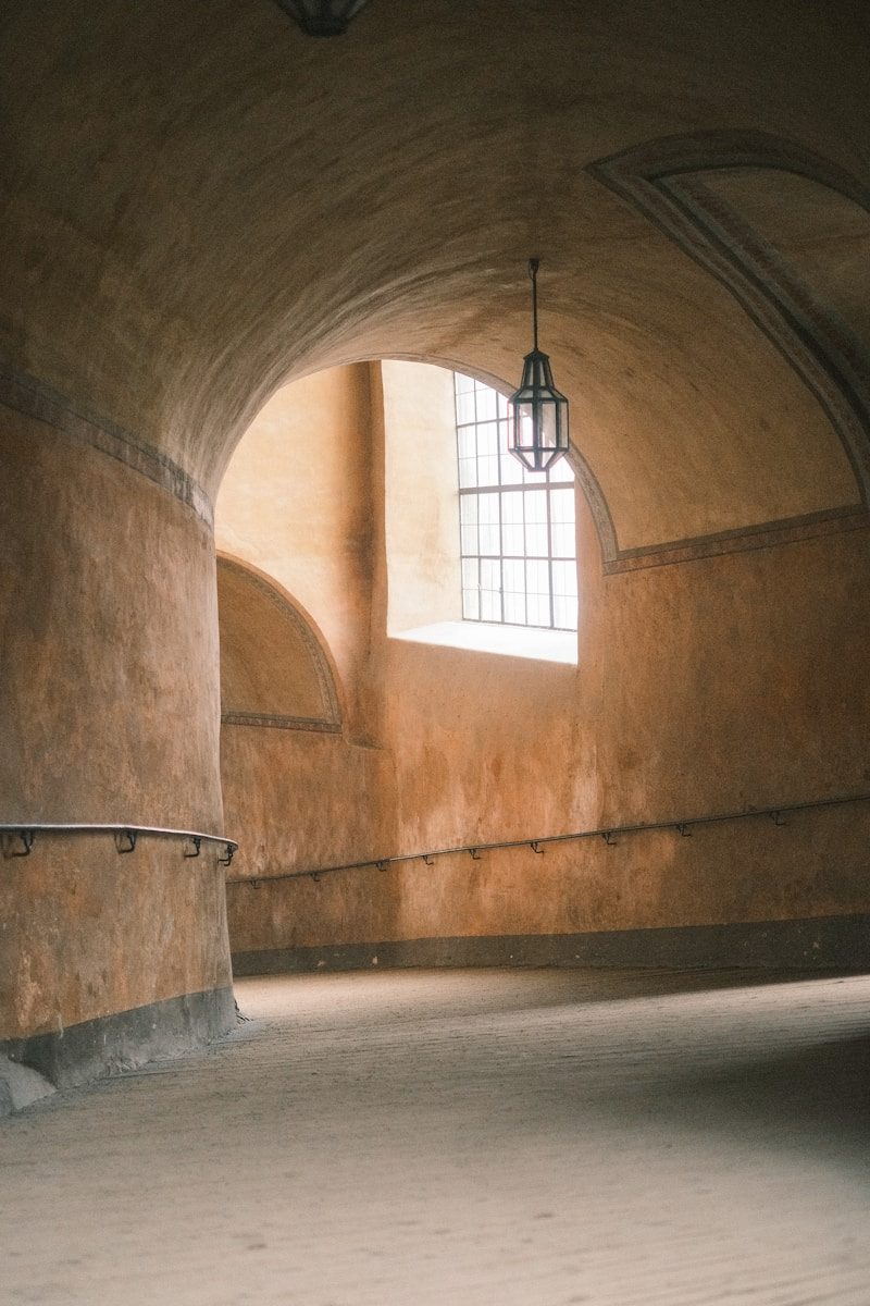 Arched hallway with a window and hanging lantern